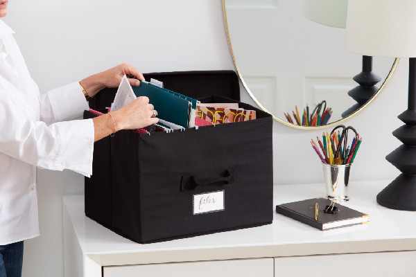 hanging files and office supplies in large black storage box