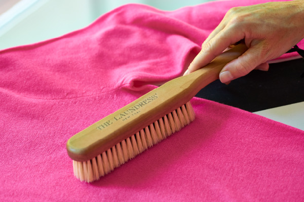 model brushing a cashmere sweater
