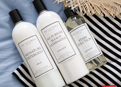 3 laundress products on stripped cotton shirt and straw hat